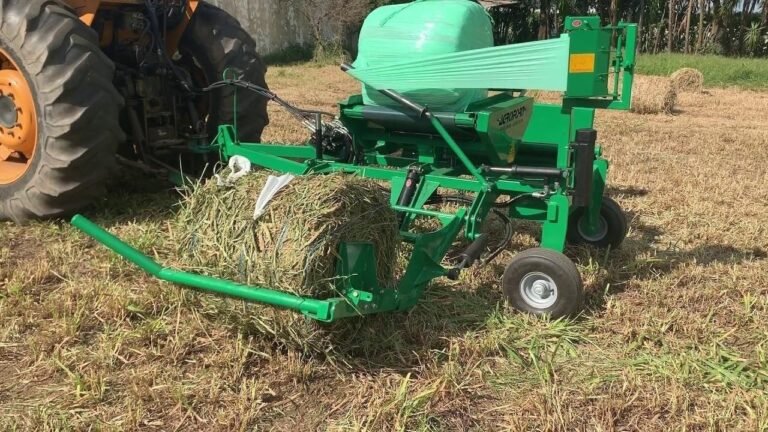 Máquina agrícola em operação no campo, com estrutura robusta manipulando feno; imagem ilustra a qualidade e eficiência dos equipamentos da Agroforn no agronegócio.